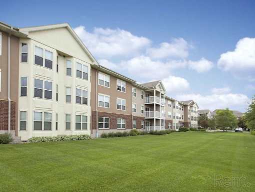 Apartment complex with a green lawn in front.