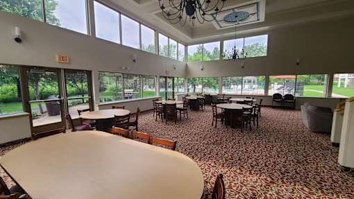 A large room with tables and chairs and a chandelier.