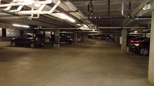 A parking garage with several cars parked.