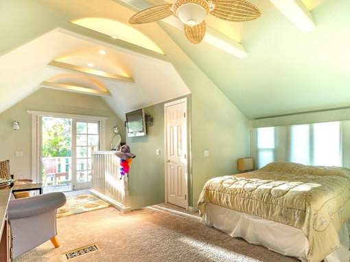 A bedroom with a bed, chair, and window.