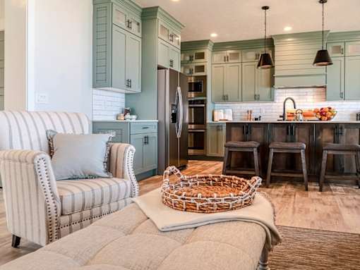A kitchen with a striped chair and a basket on the floor.