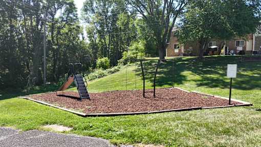A playground with a slide and a swing set.