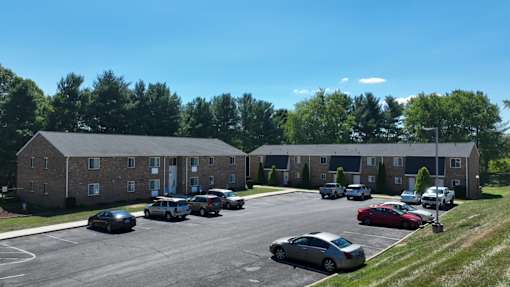 A parking lot with cars and a building in the background.