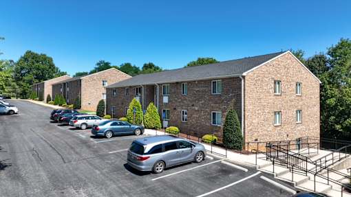 A parking lot with cars and a building in the background.