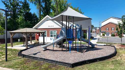 A playground with a slide and a canopy.