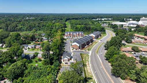 A road curves through a residential area with houses on both sides.