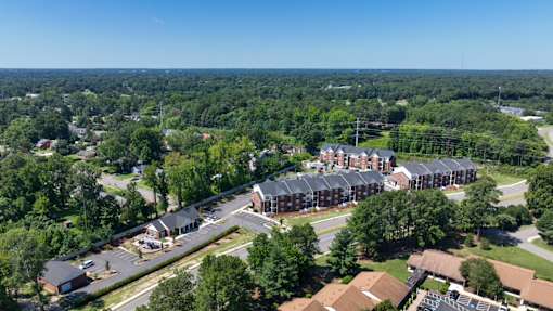 A bird's eye view of a residential area with apartment buildings and trees.