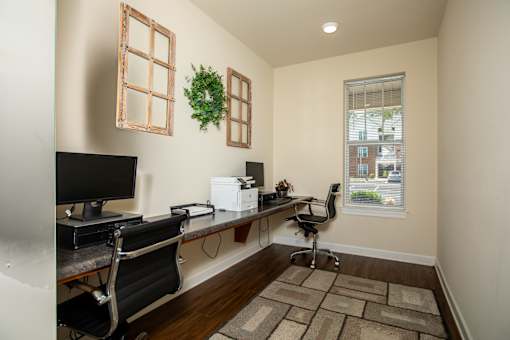 A room with a desk, chair, and a computer monitor.