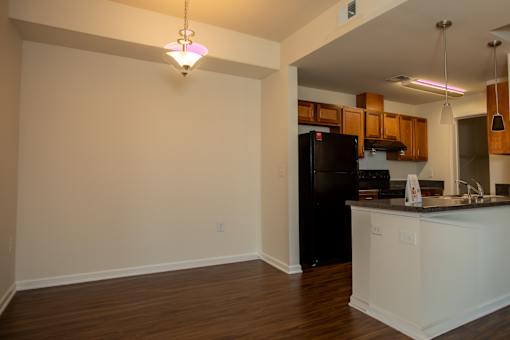 A kitchen with a black refrigerator and white countertops.