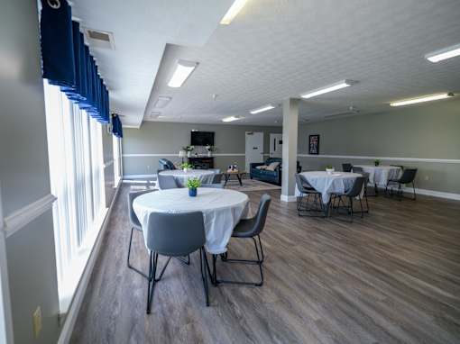 A room with a table and chairs set up for a meeting or event.