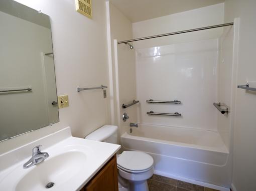 A white bathroom with a toilet, sink, and bathtub.