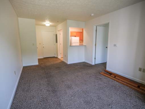 Empty room with carpeted floor and white walls.