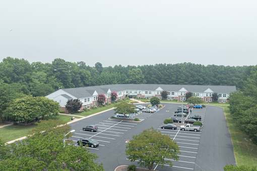 A parking lot with cars and a building in the background.