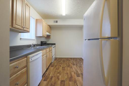 A kitchen with wooden cabinets and a white refrigerator.