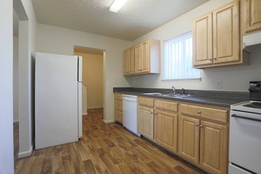A kitchen with wooden cabinets and a white refrigerator.