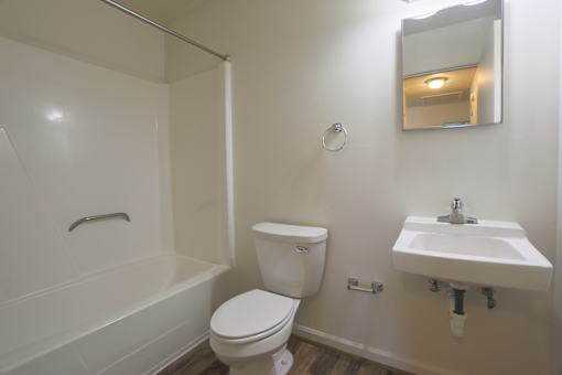 A white bathroom with a toilet, sink and bathtub.