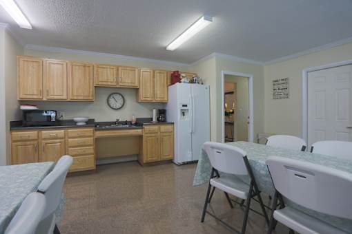 A kitchen with a table and chairs in front of it.