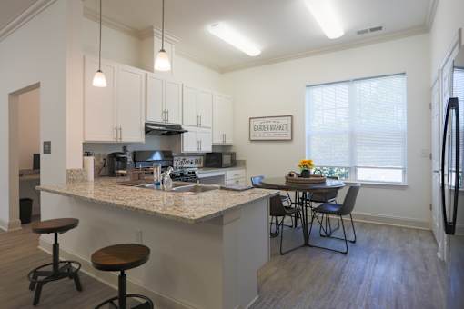 A kitchen with a granite countertop and a fridge on the right.