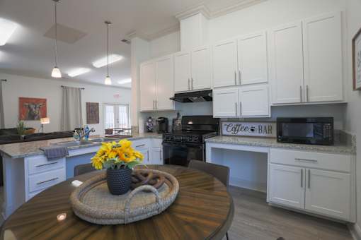 A kitchen with a table in the middle and a sign that says Coffee & Bar.