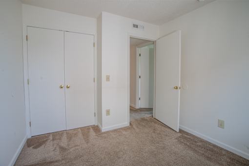 A room with two doors and a carpeted floor.