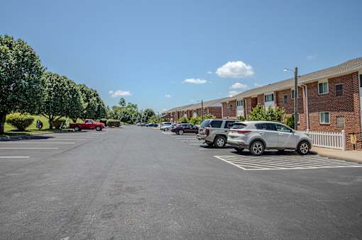 A parking lot with cars and apartment buildings in the background.
