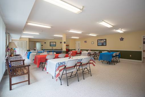 A room with tables covered in red, white and blue tablecloths.