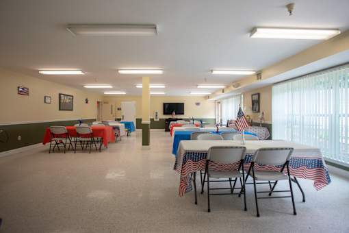 A room with tables and chairs set up for an event.