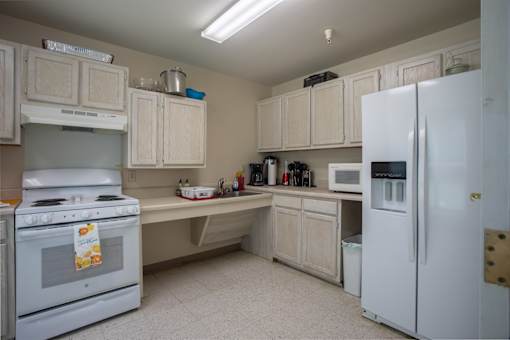 A kitchen with white appliances and cabinets.