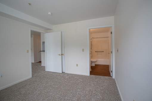 A room with a carpeted floor and a doorway leading to another room.