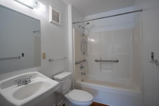 A white bathroom with a sink, toilet, and bathtub.