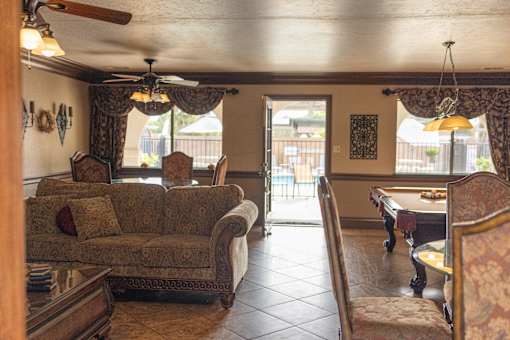 A living room with a couch, chairs, and a table.