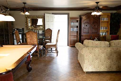 A living room with a pool table and a couch.