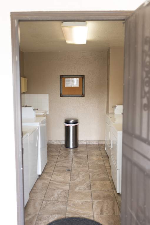 A hallway with a trash can and a picture on the wall.