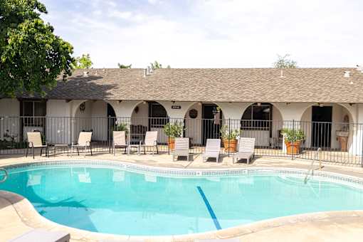 A pool with chairs around it.