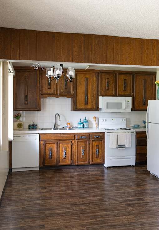 A kitchen with white appliances and wooden cabinets.