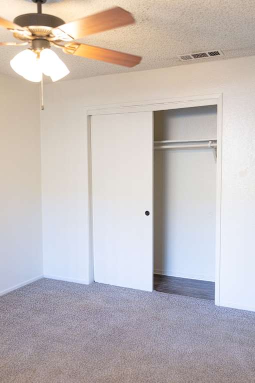 A room with a ceiling fan and two doors.