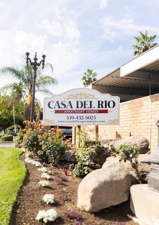 A sign for Casa Del Rio Apartments is displayed in front of a building.