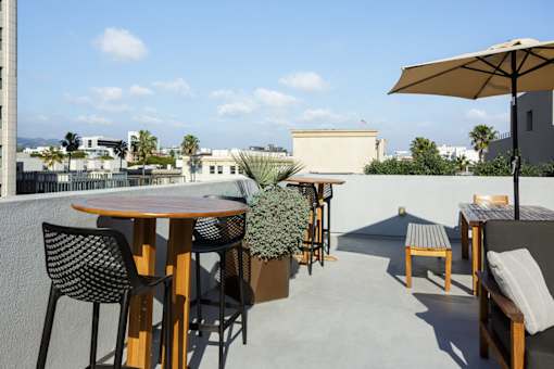A patio with a table, chairs, and an umbrella.