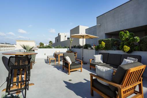 A patio with wooden furniture and a white umbrella.