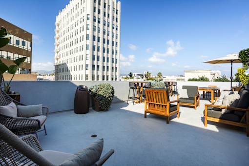 A patio with chairs and a table with a view of a tall building.