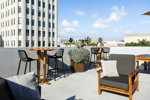A wooden chair with a white pillow is on a patio.