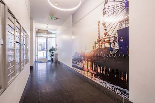 A long hallway with a large poster of a ship on the wall.