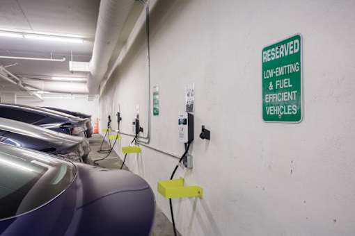 A sign in a parking garage designates a spot for low-emission vehicles.