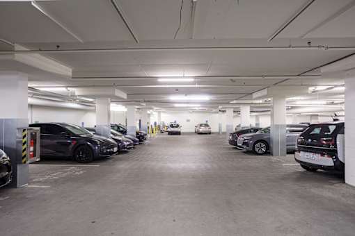 A parking garage with several cars parked.