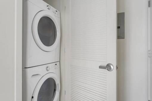 Two white front load washing machines in a laundry room.