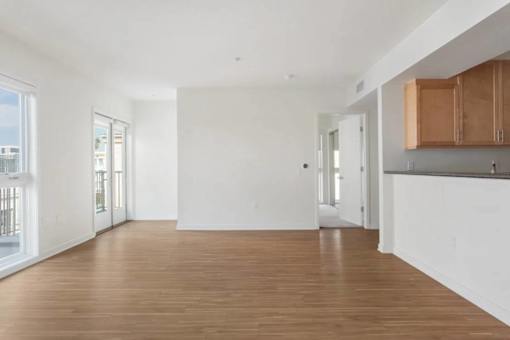 A large empty room with wooden floors and white walls.