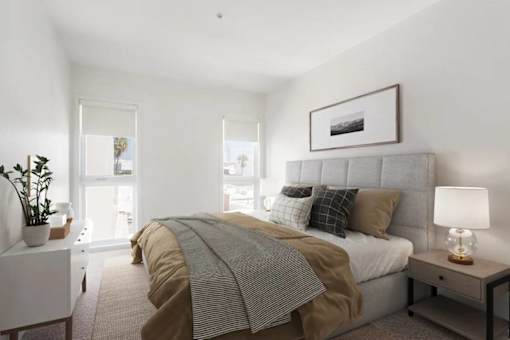 A bedroom with a bed, nightstand, and lamp.