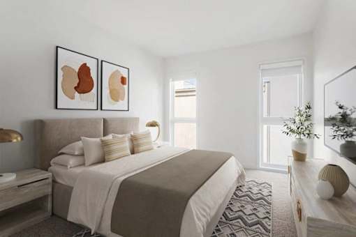 A bedroom with a large bed and two framed artworks on the wall.