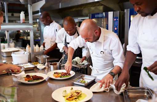 Chef preparing food in a commercial kitchen.