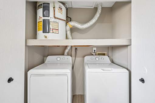 A white washing machine and dryer in a cabinet.